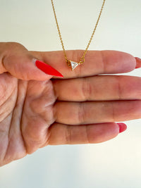 A gold thin chain necklace with a small triangular CZ diamond up close product photo