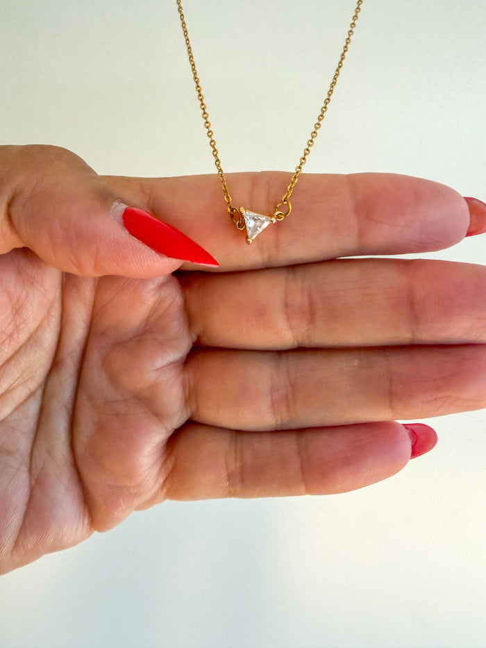 A gold thin chain necklace with a small triangular CZ diamond up close product photo