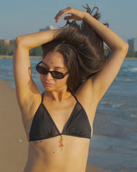 Emerson bikini charm styled on a swimsuit at the beach