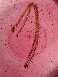 A trillion cubic zirconia diamond solitaire connector on a stainless steel gold PVD circle cable chain necklace.