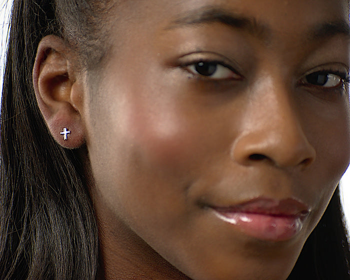 Nina cross stud earrings worn by a model